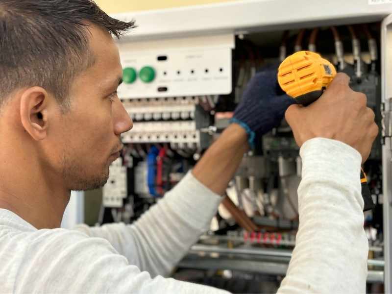 hombre dándole mantenimiento a una instalación eléctrica