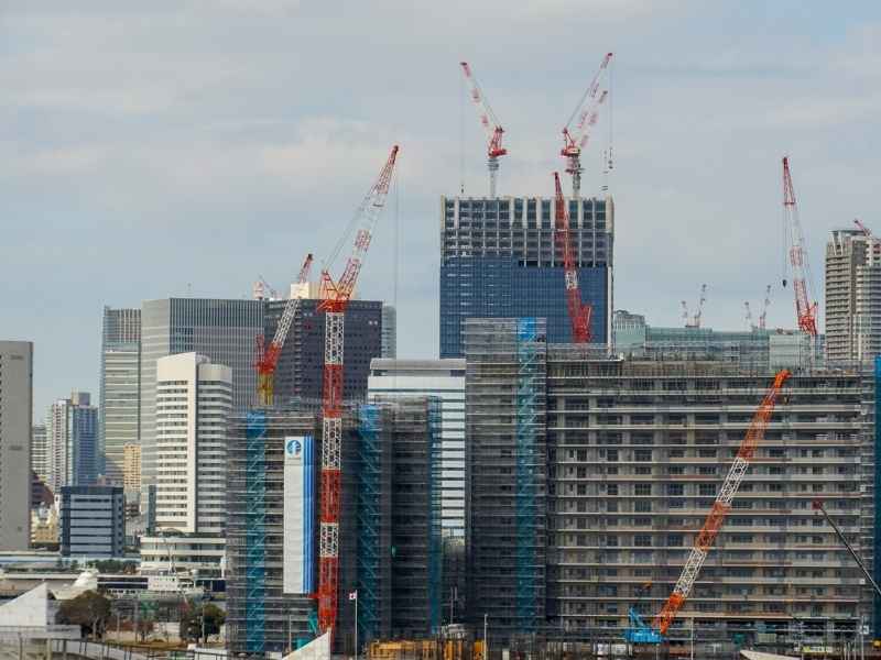 Grúas y edificios en construcción mostrando cómo la reputación de una desarrolladora crece mientras la ciudad se transforma.