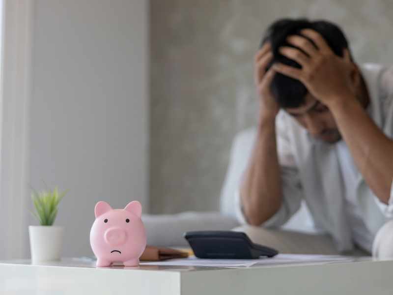 hombre haciendo cuentas y preocupado porque no le va a alcanzar para pagar sus deudas adicional a eso no tiene ahorros