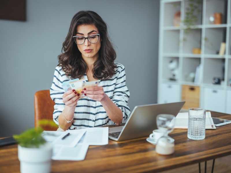 mujer apartando dinero para poder pagar sus deudas más rápido.