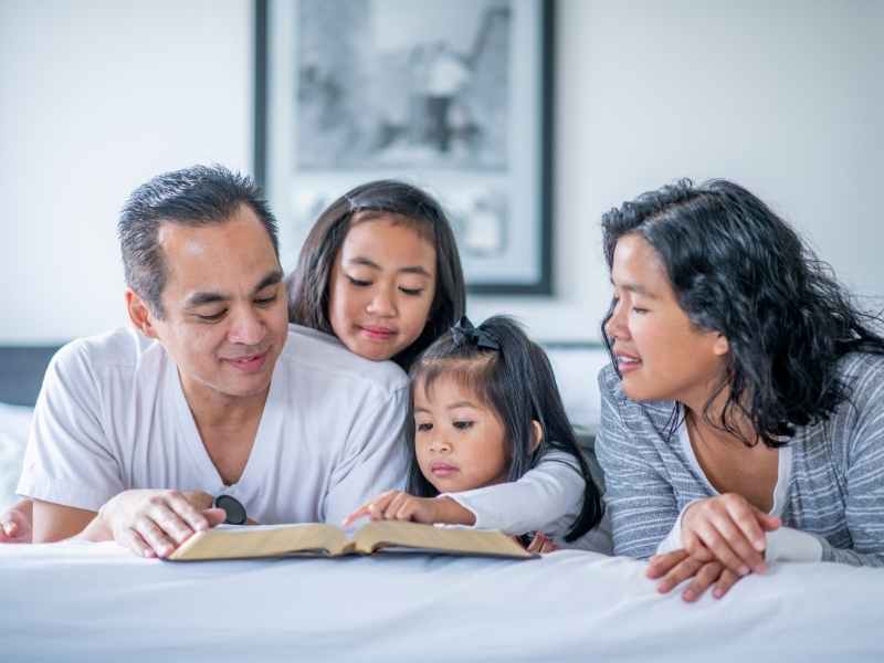 Familia guatemalteca en casa revisando documentos y aprendiendo sobre finanzas para planificar gastos y metas