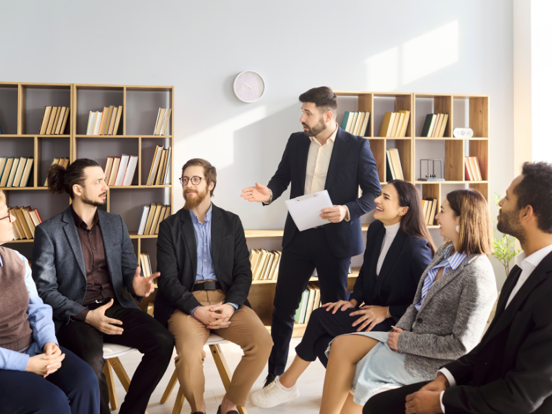 Un facilitador guía una negociación entre grupos con prioridades diferentes. 